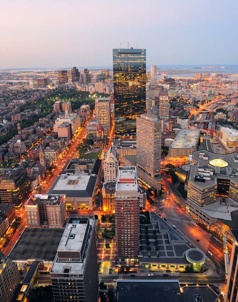 Aerial view of a city skyline at dusk, featuring a tall